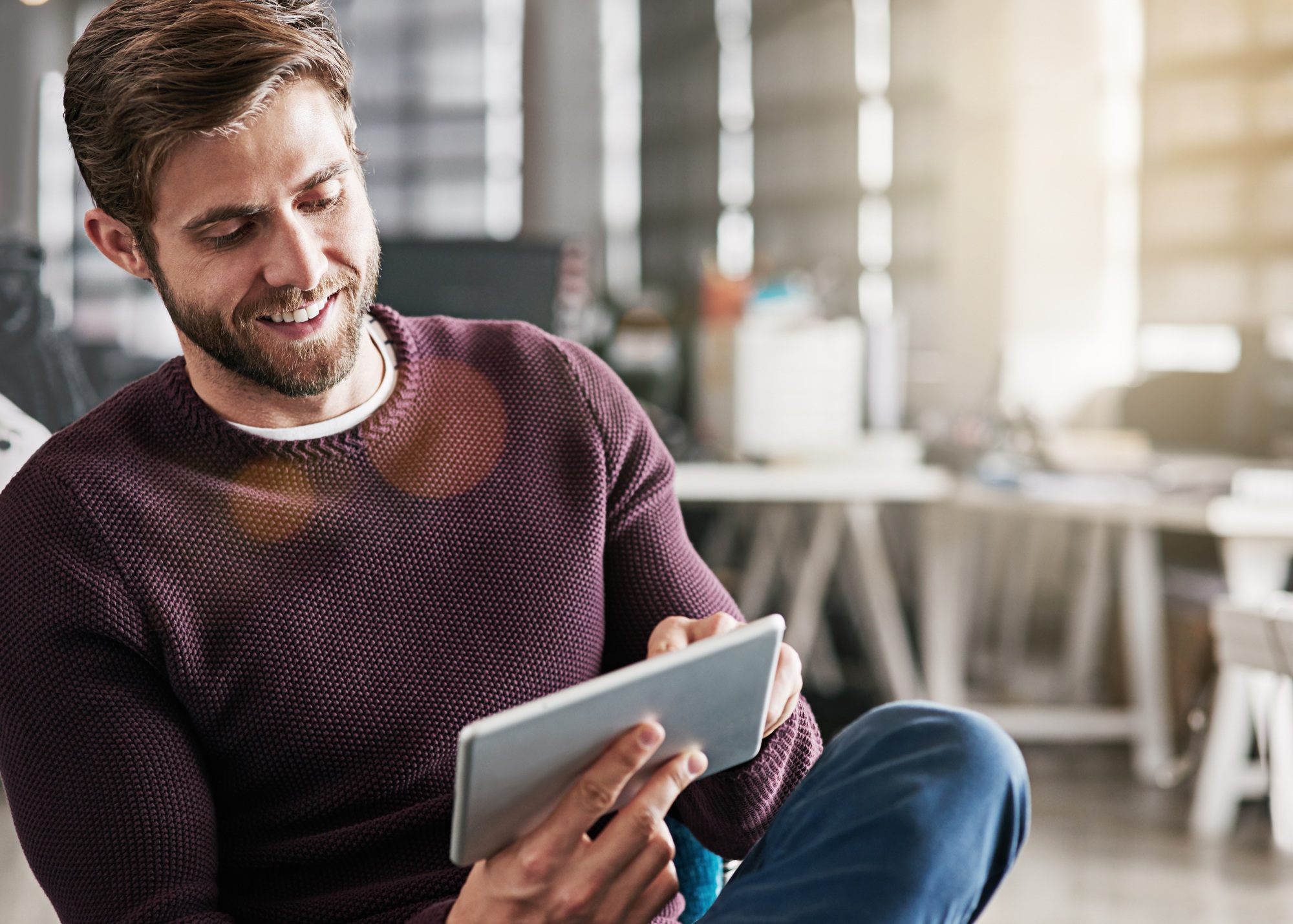 Marketing his business in a virtual world. Shot of a young man using a digital tablet in an office.